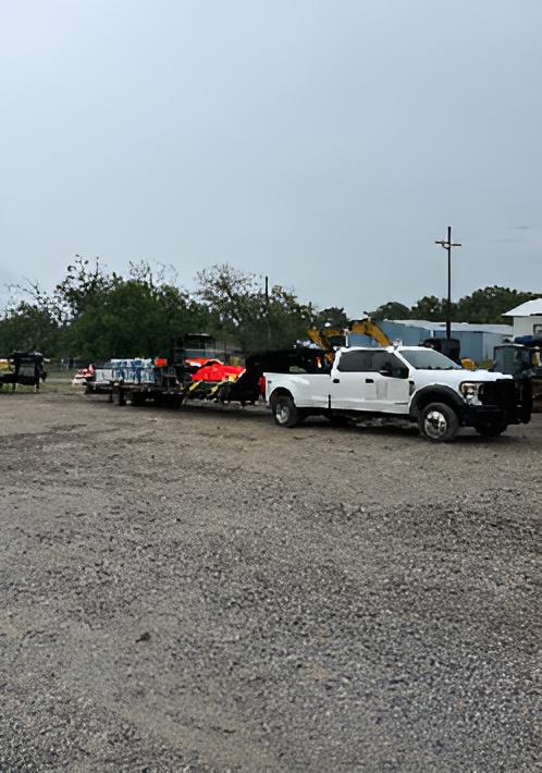 a truck with a trailer carrying lawn equipment